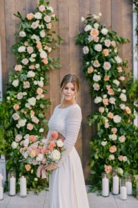 Beautiful in a white wedding dress against a background of flowers